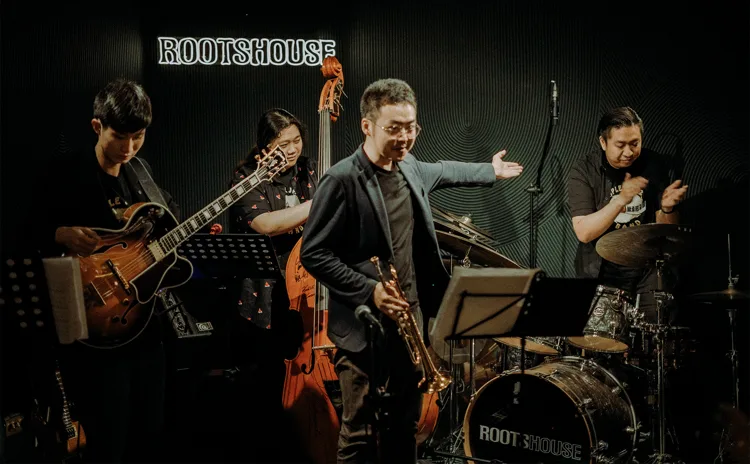 Guitar, double bass, saxophone and drums on a club stage